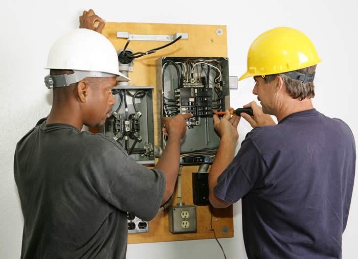 Electricians working on electrical panel